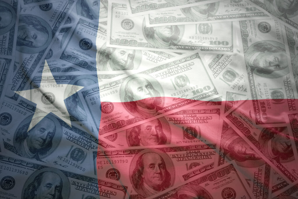 Texas flag superimposed over hundred dollar bills