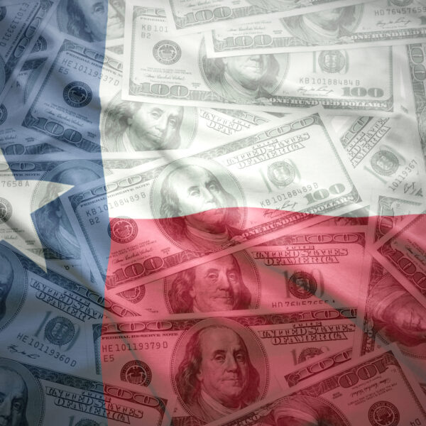 Texas flag superimposed over hundred dollar bills