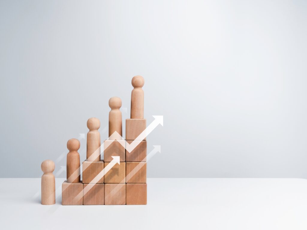 Wooden blocks and wooden shaped people are organized in a chart that indicates growth to reflect a Census Bureau report of Texas gaining residents.